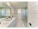 Bright bathroom featuring double sinks, marble countertops, and a frameless glass shower, creating a modern and luxurious feel at 1007 Waterline Ct, Sarasota, FL 34240
