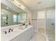 Bright bathroom featuring double sinks, marble countertops, and a frameless glass shower, creating a modern and luxurious feel at 1007 Waterline Ct, Sarasota, FL 34240