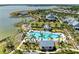 Aerial shot of community pool featuring lounge seating, palm trees, clubhouse, and lake in the background at 1007 Waterline Ct, Sarasota, FL 34240