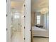 Hallway view into a modern bathroom with a frameless shower and into a cozy bedroom with comfortable décor at 1007 Waterline Ct, Sarasota, FL 34240