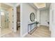 Hallway with a bathroom featuring a frameless shower, leading to a bedroom with neutral decor and ample natural light at 1007 Waterline Ct, Sarasota, FL 34240