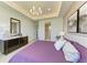 Relaxing main bedroom showcasing a tray ceiling, art decorated walls, and access to the ensuite bath at 1007 Waterline Ct, Sarasota, FL 34240