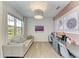 Bright home office featuring wood-look flooring, dual desks, and comfortable seating with plenty of natural light at 1007 Waterline Ct, Sarasota, FL 34240