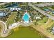 Aerial view of a community pool featuring sun loungers, palm trees, cabanas, and clear blue water on a sunny day at 1007 Waterline Ct, Sarasota, FL 34240