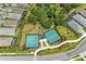 Aerial view of two tennis courts with green playing surfaces, surrounded by trees, landscaping and residential homes at 1007 Waterline Ct, Sarasota, FL 34240