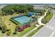 Aerial view of community tennis courts featuring fencing, greenery, pedestrian walkways, and surrounding homes at 1007 Waterline Ct, Sarasota, FL 34240