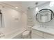 Well-lit bathroom with a tub-shower combo, modern vanity, and a round mirror at 101 25Th N St # 1, Bradenton Beach, FL 34217