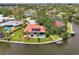 Aerial view of waterfront home featuring lush landscaping, boat dock, pool, and solar panels with water access to a canal at 1038 Contento St, Sarasota, FL 34242
