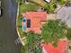 Overhead view of a home with a red tile roof, solar panels, a pool, and a boat dock on a waterfront property at 1038 Contento St, Sarasota, FL 34242