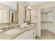 Bathroom with double sinks, framed mirrors, walk-in closet with custom shelving and wood floors at 1038 Contento St, Sarasota, FL 34242