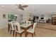 Open dining area with a glass top table, seating for six, and views of the adjacent living room at 1038 Contento St, Sarasota, FL 34242