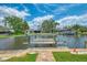 Waterfront dock featuring a boat lift and dock with water access to a canal under a sunny, partly cloudy sky at 1038 Contento St, Sarasota, FL 34242