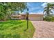 Charming single-Gathering home with a red-tiled roof, brick driveway, and tropical landscaping at 1038 Contento St, Sarasota, FL 34242