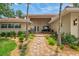 Inviting home entrance with brick pathway and lush landscaping leading to double doors at 1038 Contento St, Sarasota, FL 34242