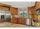 Granite countertops, wooden cabinets, and a window overlooking a pool area highlight this kitchen at 1038 Contento St, Sarasota, FL 34242