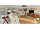 Cozy living room with white leather couches, ceiling fan, and sliding door access to the outdoors at 1038 Contento St, Sarasota, FL 34242