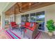 Inviting covered outdoor patio featuring comfortable seating, a ceiling fan, and sliding glass doors for seamless indoor-outdoor living at 1038 Contento St, Sarasota, FL 34242
