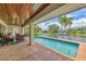 Outdoor patio featuring a covered seating area and a private pool overlooking the water at 1038 Contento St, Sarasota, FL 34242