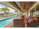Beautiful waterfront pool and covered patio with cozy seating, perfect for relaxing and enjoying the serene water views at 1038 Contento St, Sarasota, FL 34242