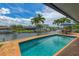 Stunning swimming pool overlooking a tranquil canal, enhanced by lush landscaping and clear blue skies at 1038 Contento St, Sarasota, FL 34242