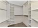 Spacious walk-in closet featuring custom shelving, hanging rods, and wood look floors at 1038 Contento St, Sarasota, FL 34242