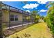 Backyard showcasing a screened patio, green lawn, and beautiful landscaping, perfect for outdoor enjoyment at 11634 Piedmont Park Xing, Bradenton, FL 34211