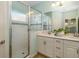 Bathroom featuring double sink vanity, white cabinets, and glass enclosed shower with mosaic tile accents at 11634 Piedmont Park Xing, Bradenton, FL 34211