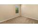 This carpeted bedroom has neutral walls and a window with blinds allowing natural light to enter at 11634 Piedmont Park Xing, Bradenton, FL 34211