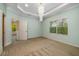 Bright bedroom featuring a modern chandelier, neutral carpet, and natural light from a window with garden views at 11634 Piedmont Park Xing, Bradenton, FL 34211