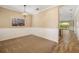 Open-concept dining room showcasing elegant light fixture, wainscoting and tan carpet at 11634 Piedmont Park Xing, Bradenton, FL 34211