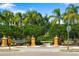 Community entrance with stone columns, lush landscaping, and caution sign for children at play at 11634 Piedmont Park Xing, Bradenton, FL 34211