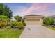 Charming single-story home showcasing a lush front lawn, flowering bushes, and an attached two-car garage at 11634 Piedmont Park Xing, Bradenton, FL 34211