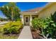Inviting front porch surrounded by lush landscaping with mature trees and flowering shrubs at 11634 Piedmont Park Xing, Bradenton, FL 34211