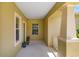 Covered front porch with neutral walls, white trim, and decorative plants that welcomes you home at 11634 Piedmont Park Xing, Bradenton, FL 34211