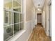 Hallway with wood floors, front door view, laundry closet and decorative hanging light fixture at 11634 Piedmont Park Xing, Bradenton, FL 34211