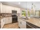 Modern kitchen boasts an island with sink, stainless steel appliances, tile backsplash and wood-look tile flooring at 11634 Piedmont Park Xing, Bradenton, FL 34211