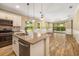 Modern kitchen boasts an island with sink, stainless steel appliances, tile backsplash and wood-look tile flooring at 11634 Piedmont Park Xing, Bradenton, FL 34211