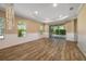 Spacious living room with tray ceiling, wood-look flooring, and sliding glass doors at 11634 Piedmont Park Xing, Bradenton, FL 34211