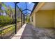 Paver patio with screened enclosure offers views of the green lawn and tropical plants at 11634 Piedmont Park Xing, Bradenton, FL 34211