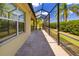 Screened patio with a brick floor overlooks a lawn and lush landscaping at 11634 Piedmont Park Xing, Bradenton, FL 34211
