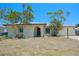 Inviting one-story home with tropical landscaping, arched entryway, and a well-maintained front yard with mature trees at 1223 De Narvaez Ave, Bradenton, FL 34209