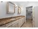Bathroom with double sinks, granite countertop, decorative mirrors, and access to a walk-in closet at 1502 Water Oak S Way, Bradenton, FL 34209