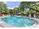 Outdoor pool with a clear blue water, surrounded by lush greenery and lounge chairs, perfect for relaxation at 1502 Water Oak S Way, Bradenton, FL 34209