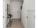 Clean entryway with a white door, neutral walls, and a small table and plant at 15117 Cuzcorro Ct, Nokomis, FL 34275