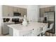 Well-equipped kitchen features gray cabinetry, stainless appliances, a large island with seating and quartz countertops at 15117 Cuzcorro Ct, Nokomis, FL 34275
