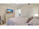 Bright bedroom features a TV, closet, and doorway to another room at 17118 Vardon Ter # 304, Bradenton, FL 34211