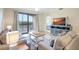 Bright living room with comfortable seating, and sliding glass doors leading to the balcony at 17118 Vardon Ter # 304, Bradenton, FL 34211