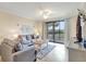 Cozy living room features a comfortable sofa, a ceiling fan, and a view of the backyard at 17118 Vardon Ter # 304, Bradenton, FL 34211