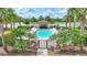 Enclosed community pool is surrounded by palm trees, lounge chairs, and manicured landscaping at 17118 Vardon Ter # 304, Bradenton, FL 34211