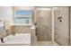 Bathroom featuring a shower with glass door, tile surround, and soaking tub at 17142 James Trl, Parrish, FL 34219